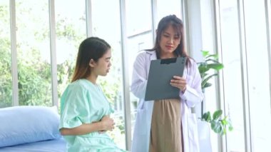 Hasta olan ve hastanede tedavi gören kadın hastaları muayene eden hamile kadın doktor hastanın semptomlarını ilk teşhisi koyuyor..