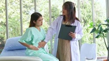 Hasta olan ve hastanede tedavi gören kadın hastaları muayene eden hamile kadın doktor hastanın semptomlarını ilk teşhisi koyuyor..