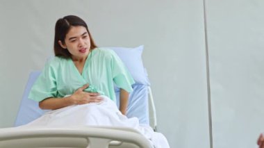 Hamile kadın doktor, karın ağrısı olan zayıf kadın hastayı muayene eder ve sorgular: doktorların güven ve etik kavramı.