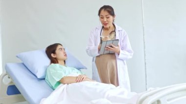 Hasta olan ve hastanede tedavi gören kadın hastaları muayene eden hamile kadın doktor hastanın semptomlarını ilk teşhisi koyuyor..