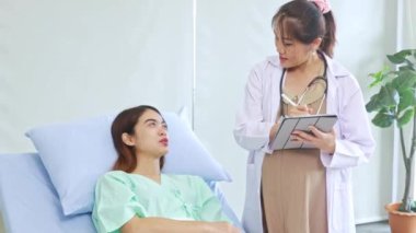 Hasta olan ve hastanede tedavi gören kadın hastaları muayene eden hamile kadın doktor hastanın semptomlarını ilk teşhisi koyuyor..