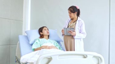 Hasta olan ve hastanede tedavi gören kadın hastaları muayene eden hamile kadın doktor hastanın semptomlarını ilk teşhisi koyuyor..