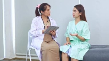 Hasta olan ve hastanede tedavi gören kadın hastaları muayene eden hamile kadın doktor hastanın semptomlarını ilk teşhisi koyuyor..