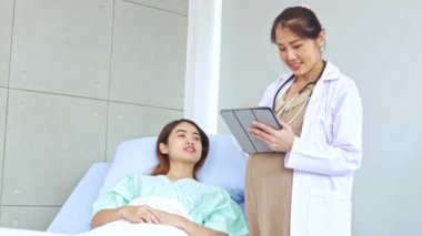 Hasta olan ve hastanede tedavi gören kadın hastaları muayene eden hamile kadın doktor hastanın semptomlarını ilk teşhisi koyuyor..