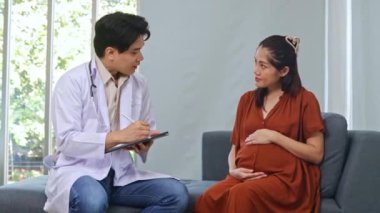 Erkek doğum uzmanı jinekolog, anne-fetal tıp uzmanı hamile kadını ve dokuz aylık fetüsünü inceliyor. Semptomları teşhis etmek için oturup faiziyle not almak..