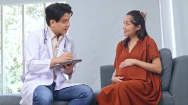 Erkek doğum uzmanı jinekolog, anne-fetal tıp uzmanı hamile kadını ve dokuz aylık fetüsünü inceliyor. Semptomları teşhis etmek için oturup faiziyle not almak..