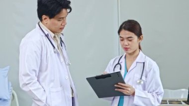 Profesyonel ekip çalışanı erkek ve kadın doktorlar hastane hastalarını tedavi eder. Kıyafetlerini giyer, toplantı yapar ve hastanın sorumlu olduğu tedavi raporunu okurlar..