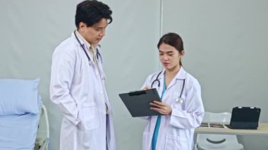 Profesyonel ekip çalışanı erkek ve kadın doktorlar hastane hastalarını tedavi eder. Kıyafetlerini giyer, toplantı yapar ve hastanın sorumlu olduğu tedavi raporunu okurlar..