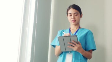 Profesyonel doktor ayakta duruyor ve çeşitli tıbbi verileri bir tablete kaydediyor ve işini düşünüyor ve planlıyor..