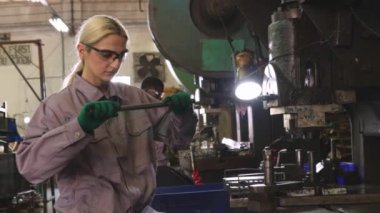 Otomotiv parçaları imalat, dönüşüm ve metal damgalama sanayisindeki bir fabrikada metal kaplama çalışmalarını denetleyen kadın fabrika mekanikleri..