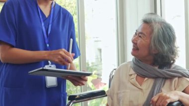 Kadın doktor tekerlekli sandalyedeki yaşlı kadın üzerinde taşınabilir kan şekeri ölçer (BGM) kullanıyor. Tedavi planının ayarlanmasını dikkate alın..