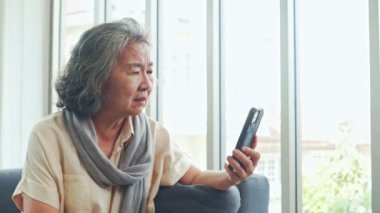 Yaşlı bir kadın kızına sohbet videosu danışmanlığı hakkında soru sormak için akıllı telefon kullanıyor. İlacını alıyor çünkü ilaç etiketindeki küçük metni anlamıyor..