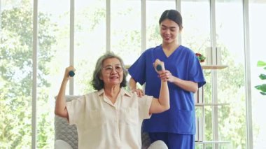 Kadın fizyoterapist, yaşlı bir kadın hastaya kas distrofisi eğitimi veriyor. Kas egzersizleri yapıyor. Kaslarını tedavi ediyor ve beriberi 'yi engelliyor..