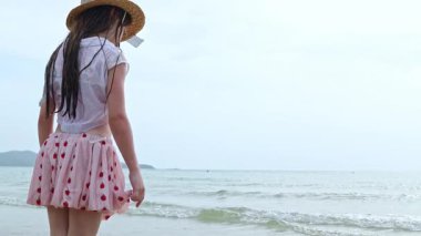 Sahilde oynayan etekli neşeli kız ve güzel kumlar: Denize koşan mutlu kız.