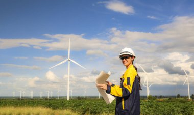 Rüzgâr çiftliğinde rüzgar enerjisi projesi planlayan kadın mimar elinde planlar ile çevre dostu konut binalarında kullanmak üzere elektrik dağıtım istasyonu tasarlıyor..