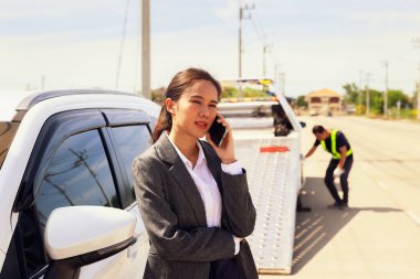 İş kadını, araba sigortası şirketinden memnuniyetsizlik ve ciddiyetsizlikle bahsediyor. Ağır hizmet, çekiş kamyonunu getiriyor. Bozuk arabayı kontrol edip tamir ederken çok zaman kaybediyor..