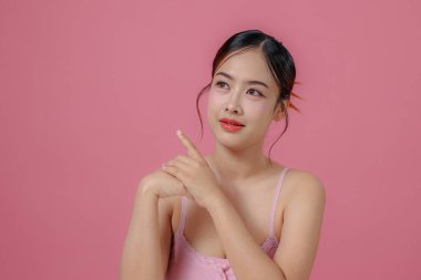 Çekici yüzlü güzel Asyalı kadın dikkat çekiyor. Sağlığınıza dikkat edin ve cildinize dikkat edin ve yumuşakça barışın büyüleyici Taylandlı kız gülümser ve kameraya bakar..