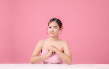 Çekici yüzlü güzel Asyalı kadın dikkat çekiyor. Sağlığınıza dikkat edin ve cildinize dikkat edin ve yumuşakça barışın büyüleyici Taylandlı kız gülümser ve kameraya bakar..