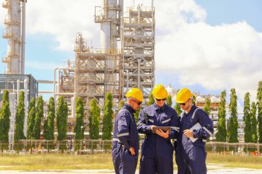 Elektrik mühendisleri kollarını kavuşturup sıra halinde beklediler. Petrol rafinerisini ve gaz ayırma alanını inceleyip güvenlik için çalışma alanındaki elektrik kontrol sistemini incelediler..