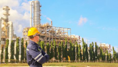 Sert şapkalı erkek mühendis, radyo raporlama önleyici bakım işleriyle birlikte basınçlı petrol ve doğalgaz boru hattının açık havada güvenlik denetimi yapan mezura üzerindeki çalışma platformunu teftiş ediyor..