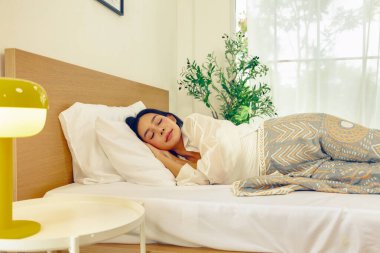 Asyalı bir kadın gün boyunca dinleniyor tatilde evde rüya görüyor ve klimalı bir yatak odasında geç uyanmak istiyor. Bu onu daha iyi uyutuyor..