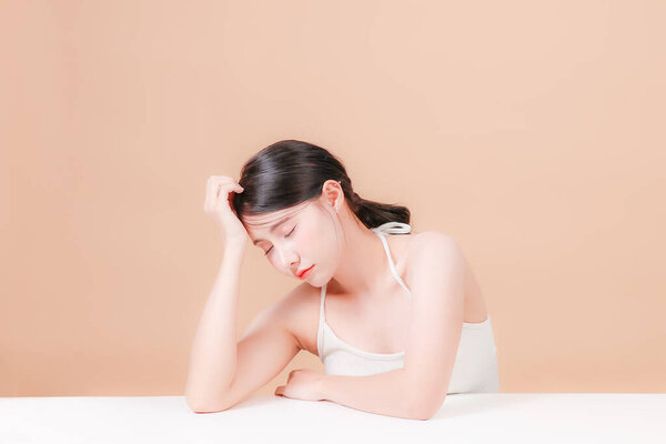 Portrait young asian woman sitting and thinking stressed about taking care of her health and skin to be beautiful and clean with aura all the time : Bored and unhappy Thai teenage girl.