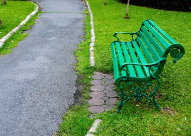 Yeşil çimlere kurulmuş koltuklu park geçidi