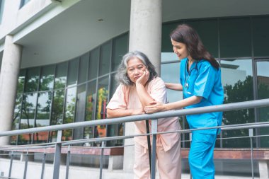 Asyalı kadın doktor, depresyondan, yaşlılara ve sağlık hizmetleri konseptine üzüldüğü yaşlı hastalara iyi bakın ve onları teşvik edin..