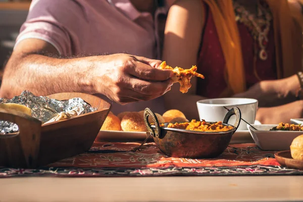 Close-up of Indian father\'s hand Picking up Indian food, which is to food culture of Indians, to Indian family and food concept.