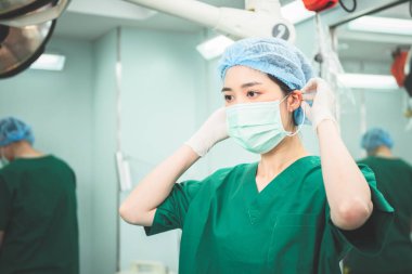 Asian female doctor, attractive and young wearing a mask to prepare for work in the operating room. to people health care and surgery concept.