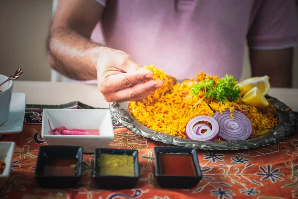 Close-up of Indian man\'s hand Picking up Indian food, which is to food culture of Indians, to Indian family and food concept.