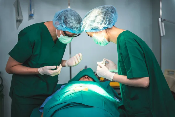 Blurred soft images, Asian medical team women and men Looking at skin area of the patient\'s requiring surgery which lying on bed in the operating room,  to people health care and surgeon concept.