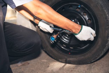 Erkek tamirci, turistlerin lastiklerini değiştirmek için ingiliz anahtarı kullanıyormuş. işçi ve ulaşım kavramına.