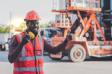 African American workers man, working in containers industry, logistic transport Import-Export Cargo, to business shipping and storage port terminal concept.