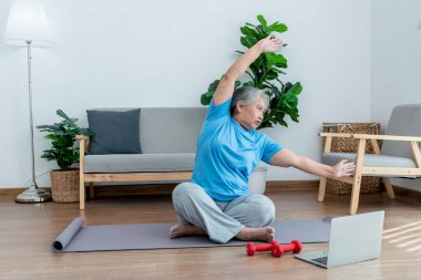 Asyalı yaşlı kadınlar, oturma odasındaki temel pozisyonda yoga yapıyorlar, ki bu bir ısınma ve meditasyon egzersizi, yaşlı sağlık hizmetleri konseptine..