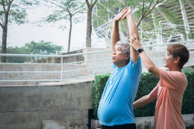 Asian family, Son helping elderly father which is obese in the belly to exercise starting from stretching the arm muscles. to elderly health care and exercise concept.