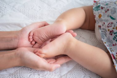 Bebeğin ayağının annenin eline konması, çocuklarına sevgi ve ilgi gösterme konsepti ve aşk aile ilişkisidir..