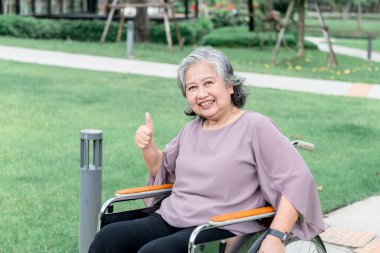 Portre resmi, tekerlekli sandalyede oturan Asyalı yaşlı bir kadın, gülümsedi ve mutluydu. emeklilik yaşı ve sağlık hizmetleri kavramına.