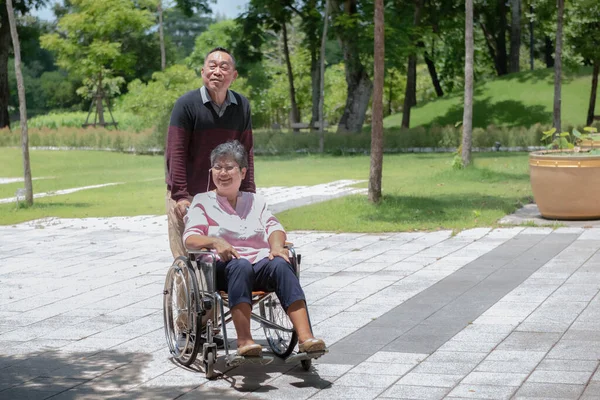 Asyalı çift. Orta yaşlı koca, tekerlekli sandalyedeki karısına bakıyor. Parkta insanlarla ve Asyalı ailelerle olan ilişkileriyle rahatlıyor.