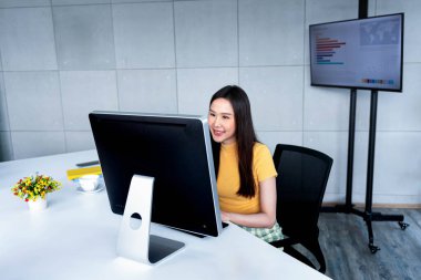 Ofiste çalışan Asyalı iş kadını ofiste tablet ve dizüstü bilgisayar belgeleri kullanıyor.