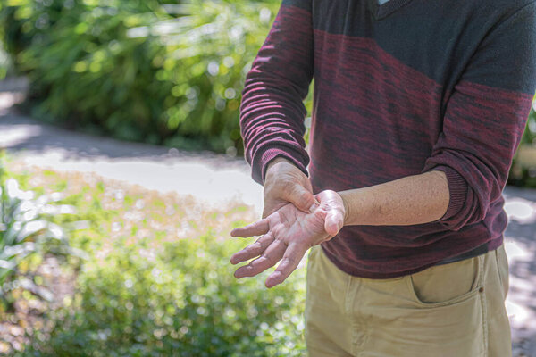 Elderly person is demonstrating acupressure on palm for therapy