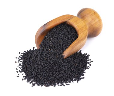 Tahta kepçe içinde siyah kimyon tohumları, beyaz arka planda izole. Bir yığın siyah nigella tohumu. Nigella sativa