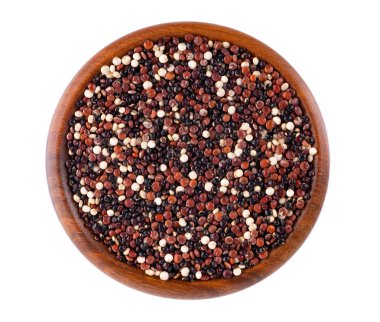Beyaz arka planda izole edilmiş, tahta kasedeki kinoa tohumları. Beyaz, kırmızı ve siyah kinoanın karışımı. Üst görünüm