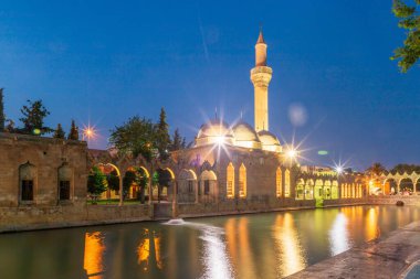 Türkiye 'nin Sanliurfa kentindeki güzel günbatımı manzarasında Balikli Gol ve Rizvaniye Camii manzarası.