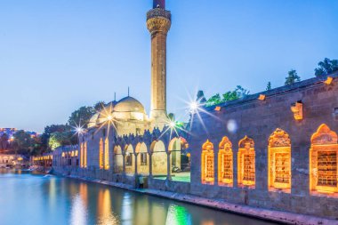 Türkiye 'nin Sanliurfa kentindeki güzel günbatımı manzarasında Balikli Gol ve Rizvaniye Camii manzarası.