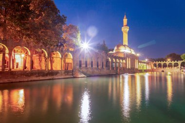 Türkiye 'nin Sanliurfa kentindeki güzel günbatımı manzarasında Balikli Gol ve Rizvaniye Camii manzarası.