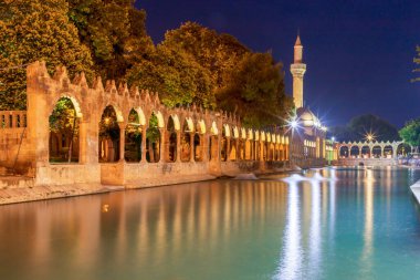 Türkiye 'nin Sanliurfa kentindeki güzel günbatımı manzarasında Balikli Gol ve Rizvaniye Camii manzarası.