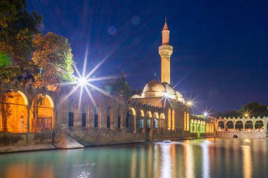 Türkiye 'nin Sanliurfa kentindeki güzel günbatımı manzarasında Balikli Gol ve Rizvaniye Camii manzarası.
