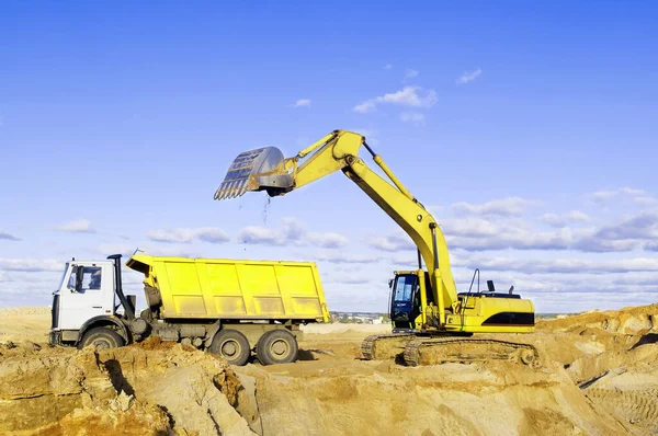 装载采石场卡车的典型黄色挖掘机 — 图库照片