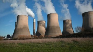 Passenger train passing in front of cooling towers